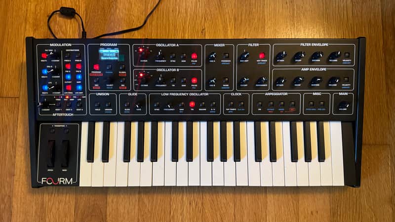 Black synthesizer keyboard with white keys and various knobs and sliders.
