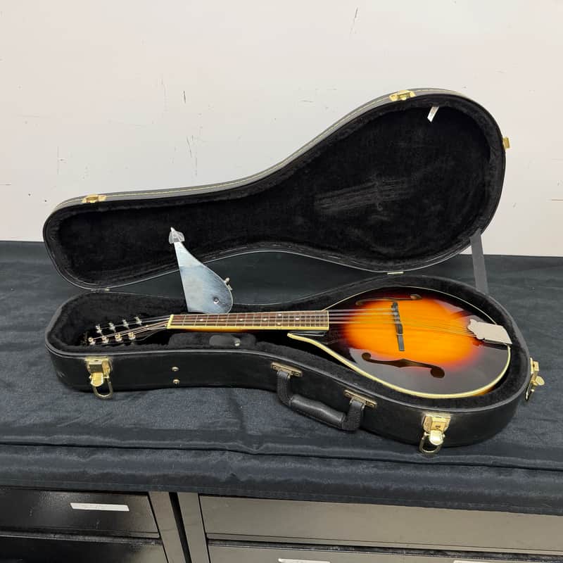 Vintage Kentucky acoustic guitar, brown and black, displayed upright.