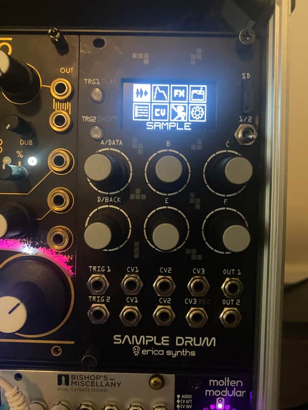 Black electronic drum module with knobs, jacks, and digital display.