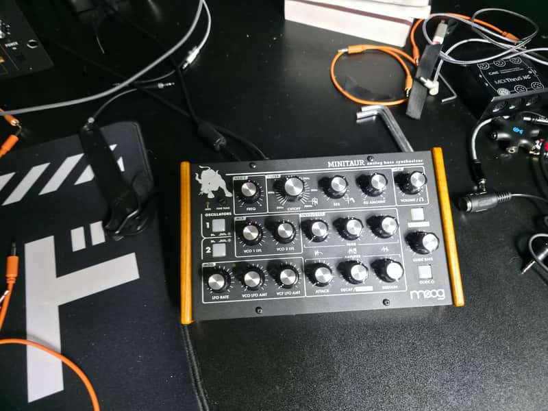 Black synthesizer panel with numerous knobs and displays. Analog electronic instrument.
