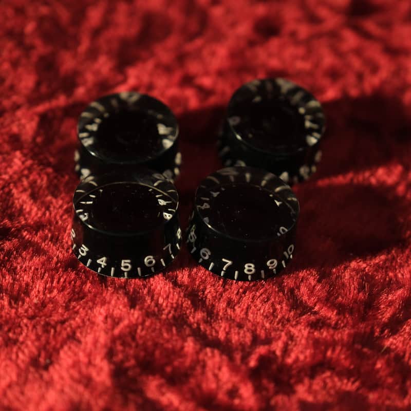 Three white, numbered, circular plastic tokens on red fabric.