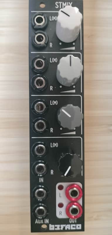 Black and silver audio mixing board with multiple knobs and jacks.