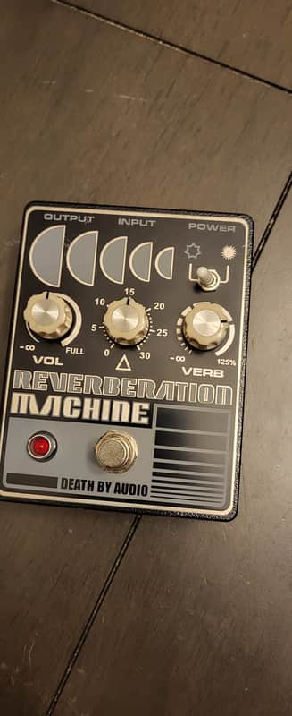 Black and silver reverb machine pedal with knobs and input/output jacks.