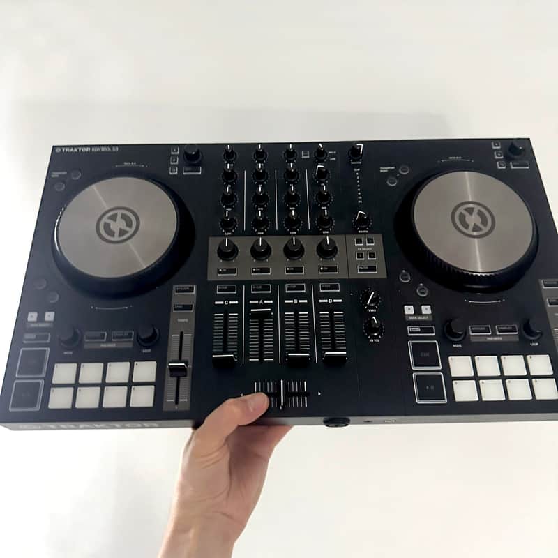 Black electronic mixer with two large silver jog wheels and blue illuminated controls.