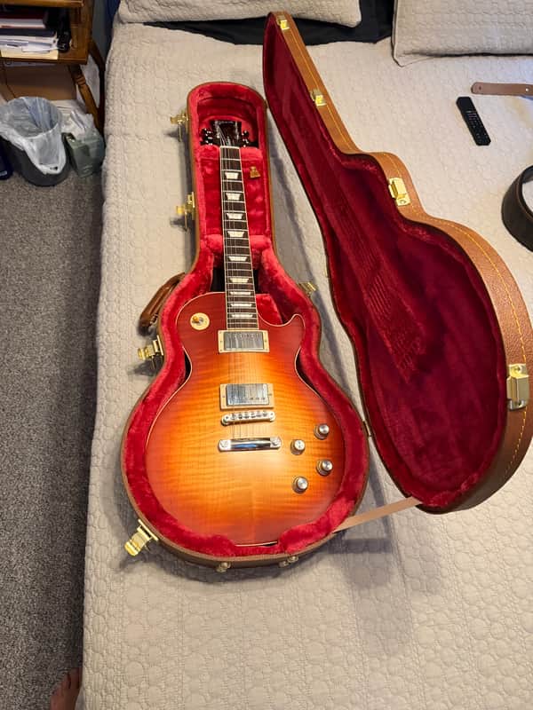 Vintage sunburst electric guitar in red velvet case, good condition.