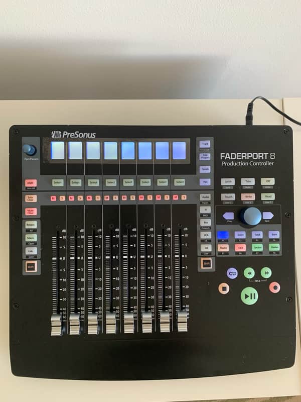 Black PreSonus Faderport 8 audio production controller on a wooden surface.