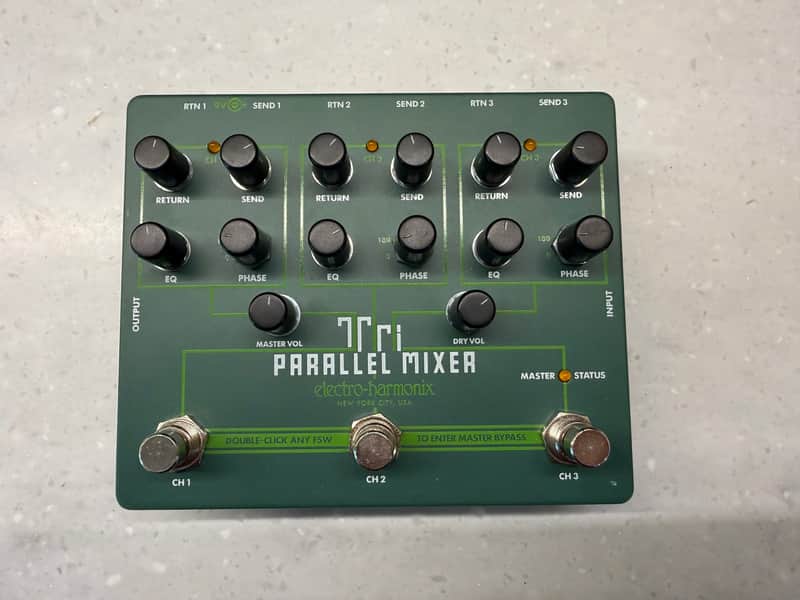 Green audio mixer with three channels, knobs, and labeled inputs/outputs.