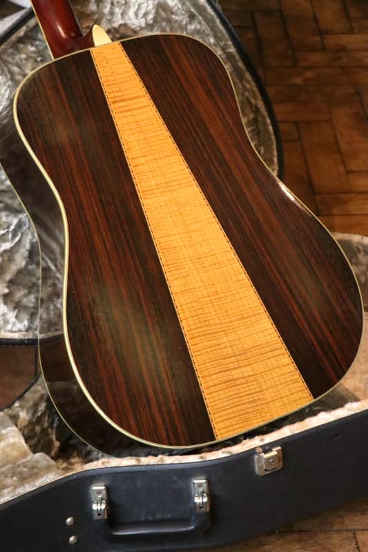 Brown and tan acoustic guitar body resting on a black case.