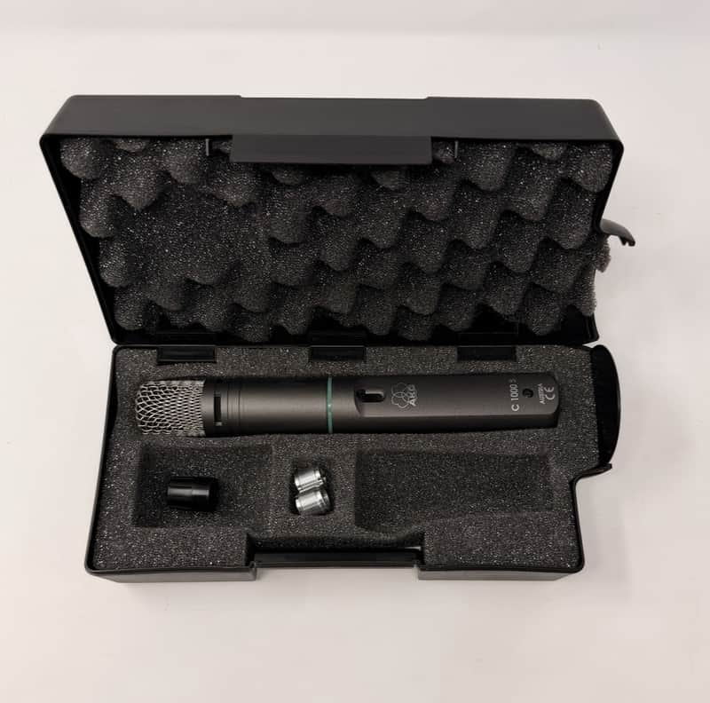 Two silver and white microphones with black accents on a black surface.