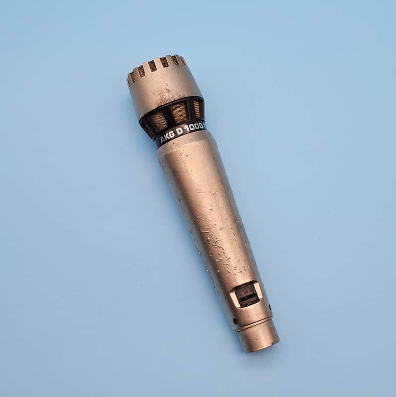 Gold and black flashlight displayed on a black box against a red background.