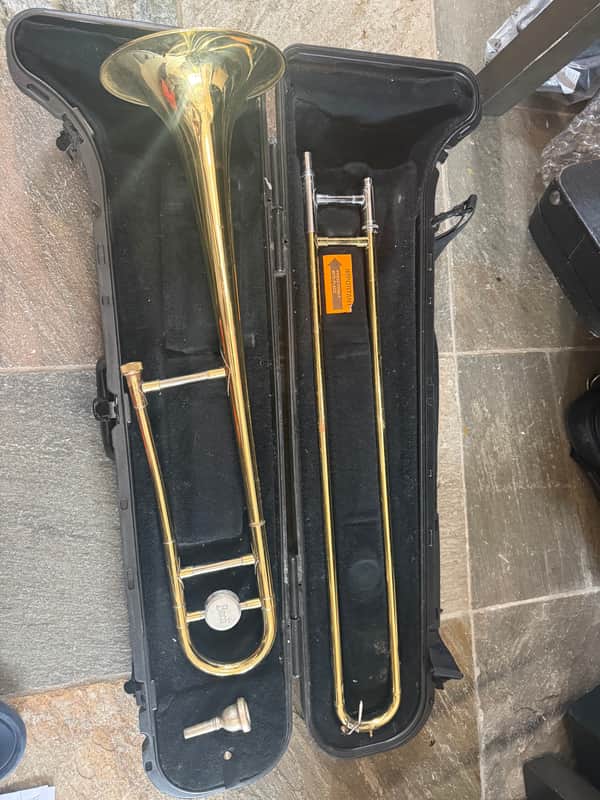 Gold trumpet in black carrying case, open, showing mouthpiece and bell.