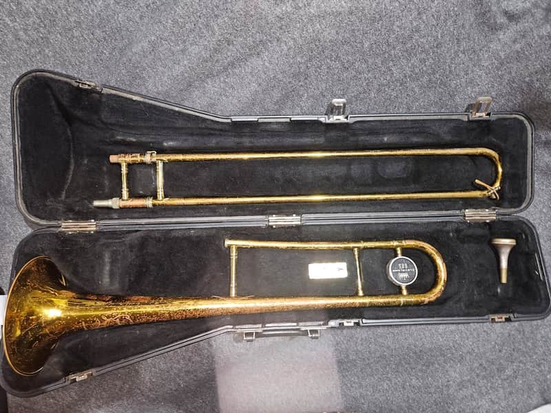Gold trumpet in open black velvet-lined carrying case.