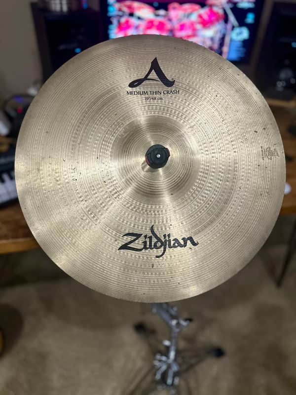 Silver cymbal with "Zildjian" logo, showing signs of use.