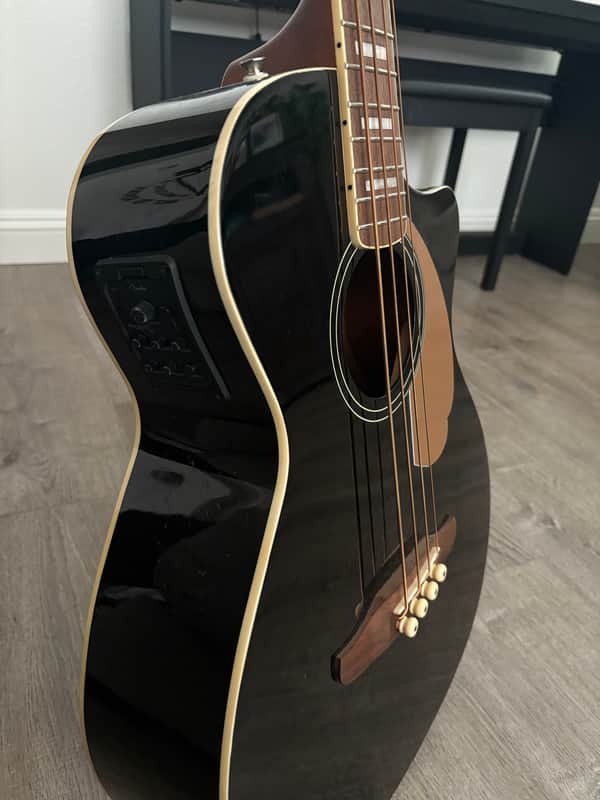 A solid wood acoustic guitar, natural blonde finish, displayed against a gray background.