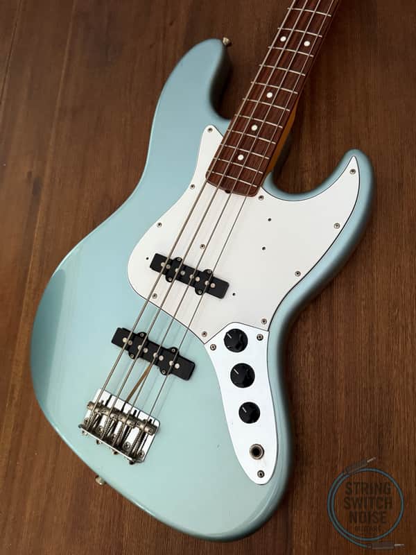 Light blue bass guitar with tortoiseshell pickguard, visible hardware.