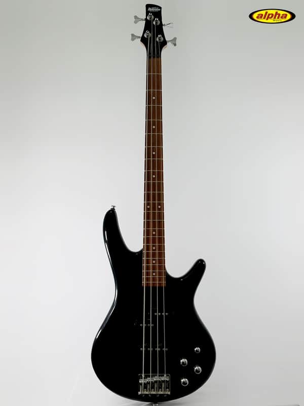 Black electric guitar on stand, resting on a textured couch.