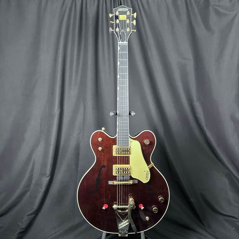 Brown Gibson electric guitar with gold pickguard, visible hardware.