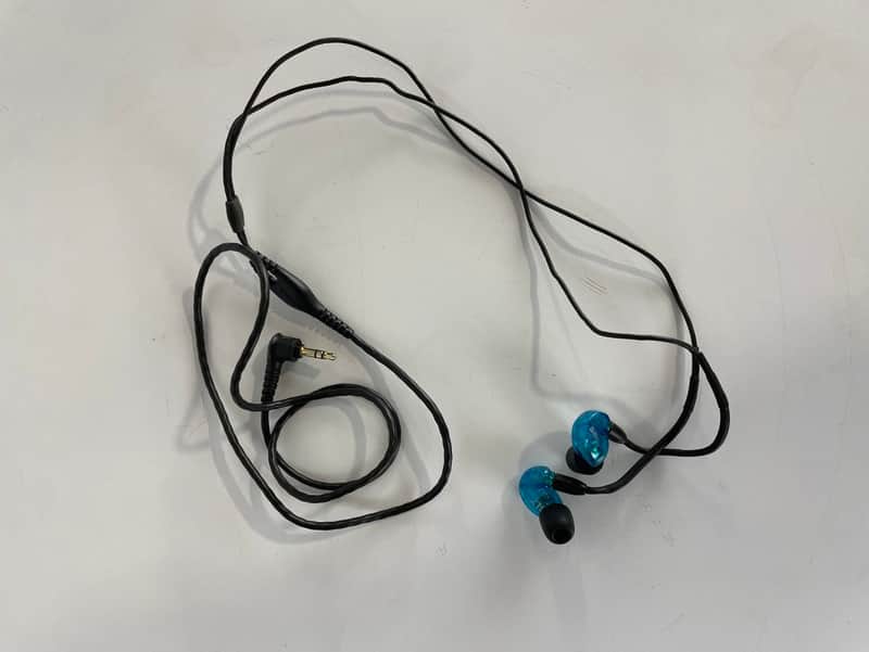 Blue and black Shure SE215 earphones in original packaging.