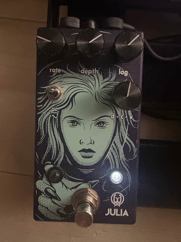 Blue guitar pedal with light blue hair illustration, knobs visible.