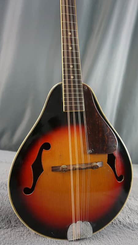A solid yellow acoustic guitar with a dark pickguard and visible tuning pegs.
