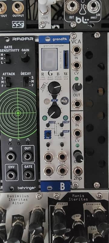 Granular sampler electronic device with white and black knobs and controls.