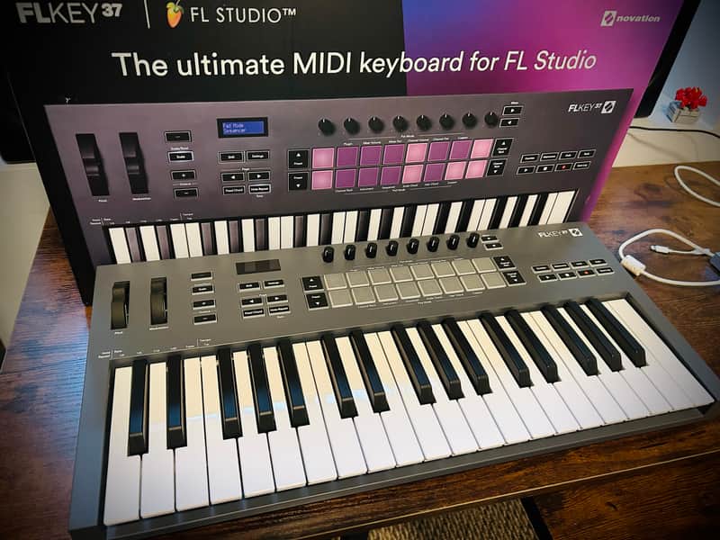 Black electronic keyboard with white keys, resting on wood floor.