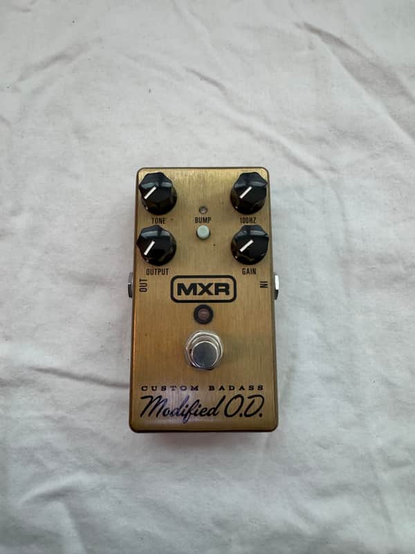 Gold and silver guitar effects pedal with knobs and "MXR Custom Badass Modified O.D." text.
