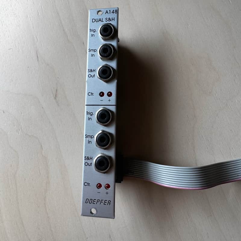 White and black guitar strap in open brown cardboard box.