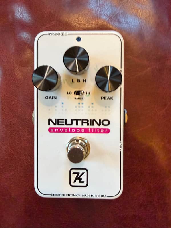 White electronic pedal with knobs, labeled "NEUTRINO envelope filter.