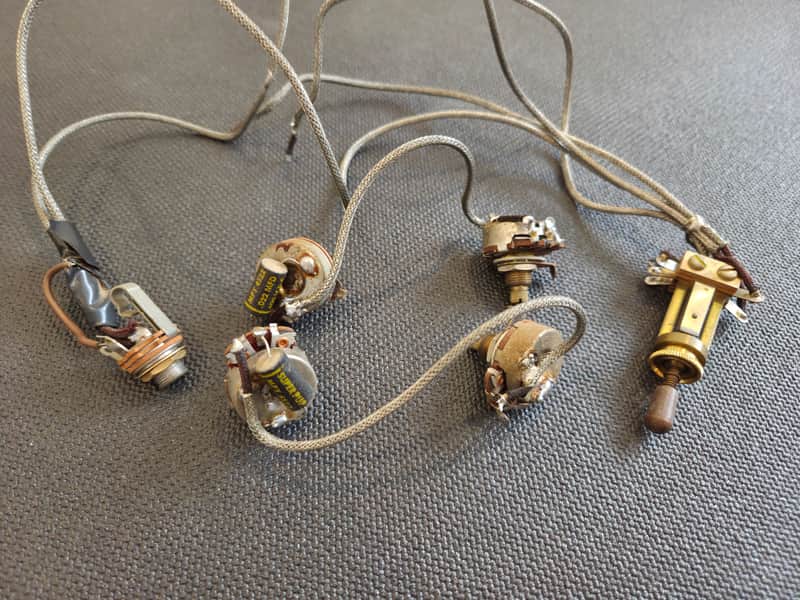 Multiple silver and black electronic components with wires on a white surface.