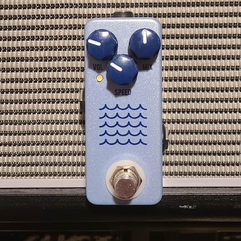 Blue and silver guitar effects pedal with knobs and wave graphic.