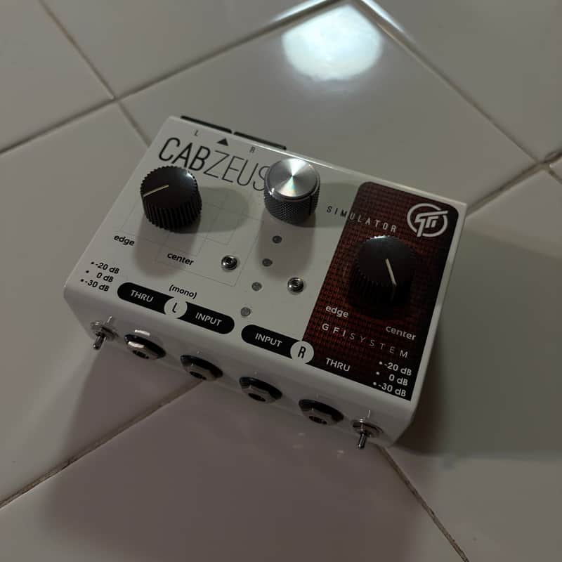 White and black guitar effects pedal with knobs and labeled inputs/outputs.