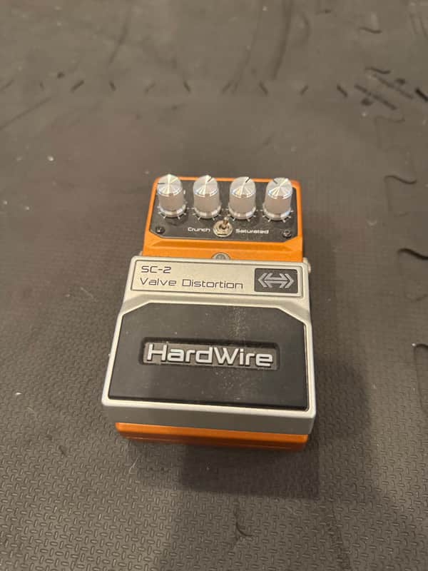 Orange and silver guitar distortion pedal with knobs and switches.
