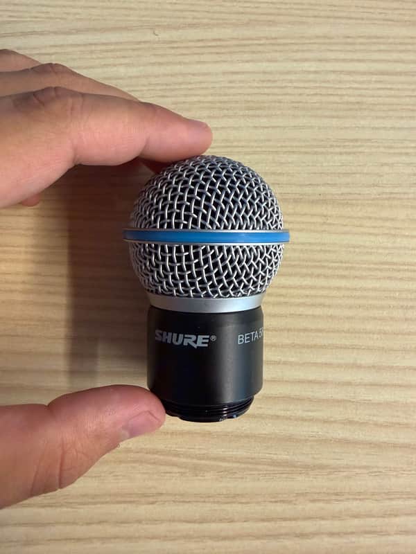 Four black and silver microphones with blue rings, lined up on a black case.