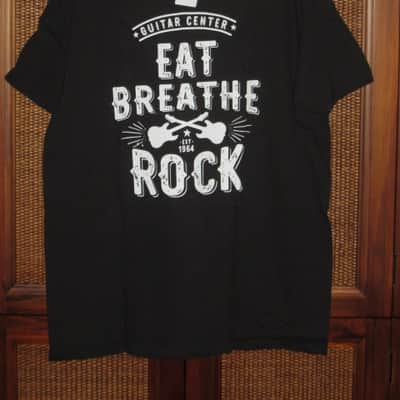 new in package A+ Guitar Center EAT BREATHE, ROCK Men's Size Large (L), Black 100% Cotton Short Sleeve T-Shirt - Graphic is in White and it says / shows: GUITAR CENTER EST. 1964, EAT, BREATHE, ROCK + has dual guitars, stars, & lines (Style # GC005-11730) image 1