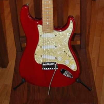 2000 Fender American Deluxe Stratocaster Ash body with Maple Fretboard. Crimson Transparent Red. Perloid dots with Lace Sensor pickups. Pickgurad has been changed to white. Comes with period correct fender hard shell case and original perloid pickguard. for sale