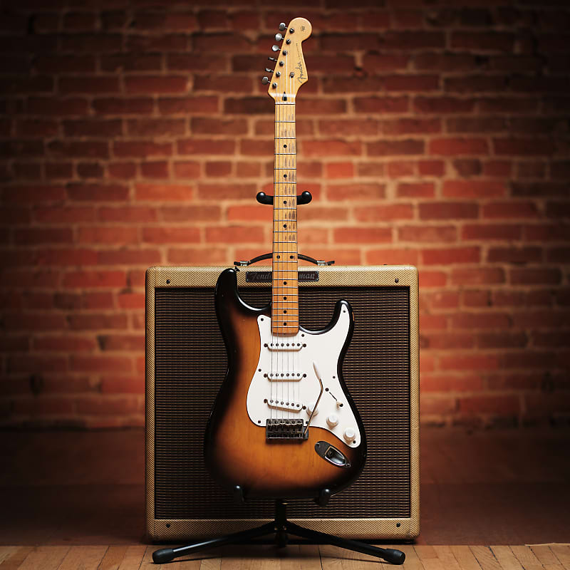 1954 STratocaster on a stand in front of an amp.